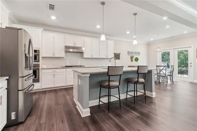 kitchen featuring under cabinet range hood, tasteful backsplash, ornamental molding, and stainless steel appliances