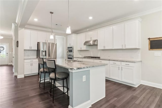 kitchen with dark wood finished floors, crown molding, a center island with sink, white cabinets, and under cabinet range hood