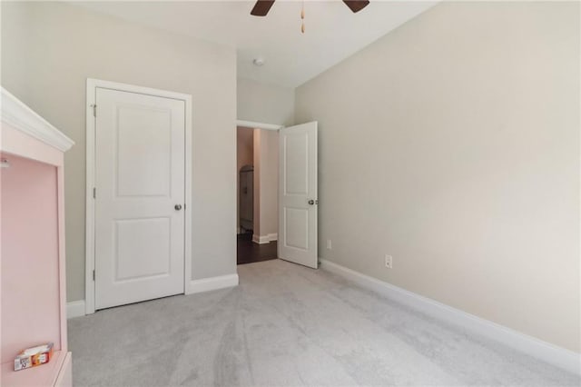 unfurnished bedroom featuring light carpet, ceiling fan, and baseboards