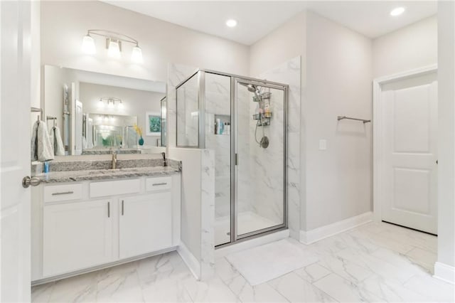 bathroom with marble finish floor, a marble finish shower, vanity, and baseboards