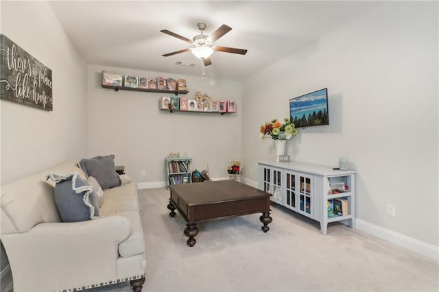 living area featuring ceiling fan, carpet flooring, visible vents, and baseboards