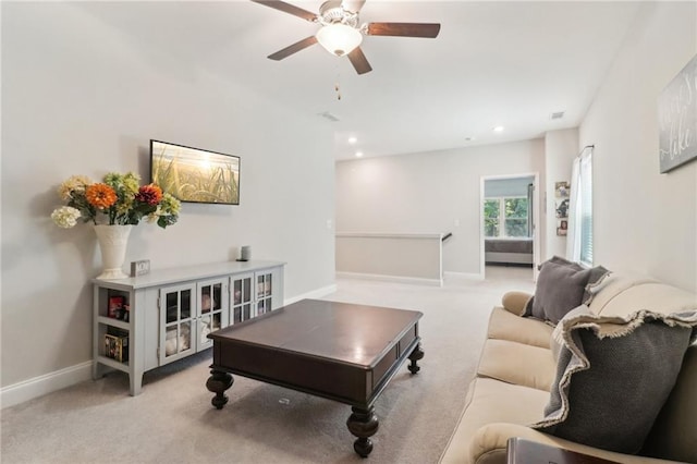 living room with a ceiling fan, recessed lighting, light colored carpet, and baseboards