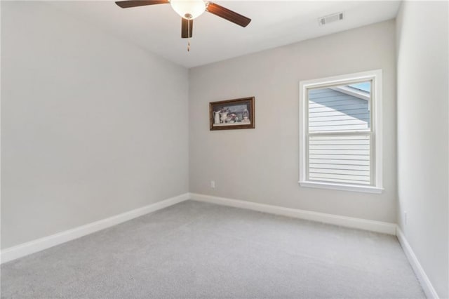 spare room with a ceiling fan, visible vents, light carpet, and baseboards