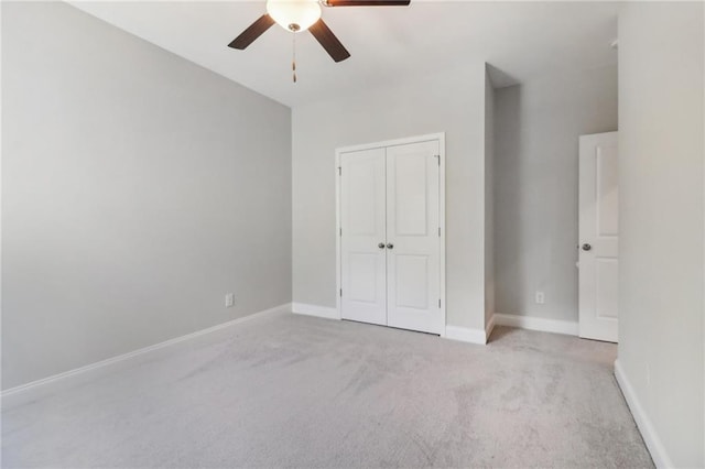 unfurnished bedroom with a ceiling fan, a closet, baseboards, and carpet flooring