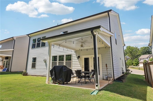 rear view of property with a patio, a lawn, and a ceiling fan