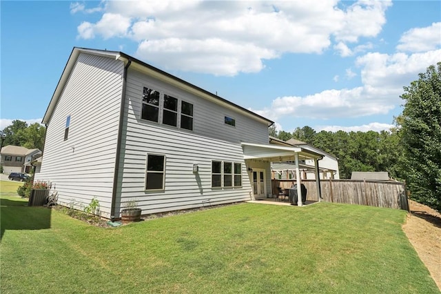 rear view of property featuring a yard, fence, and a patio