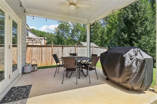 view of patio featuring a ceiling fan, outdoor dining area, a fenced backyard, and grilling area