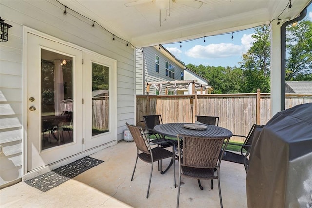 view of patio with ceiling fan, outdoor dining area, area for grilling, fence, and french doors