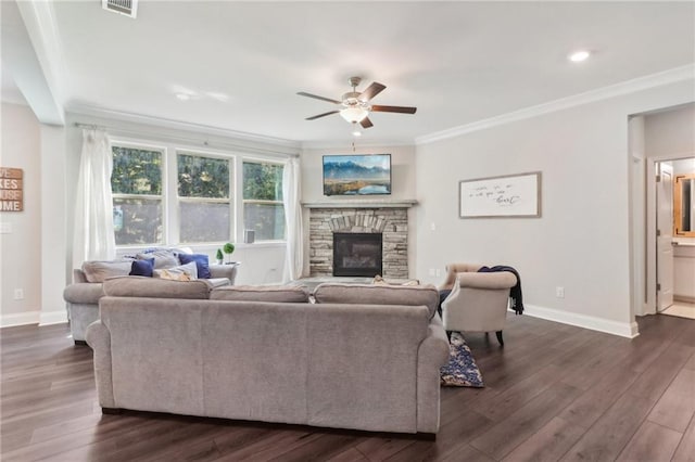 living area featuring dark wood-type flooring, a fireplace, crown molding, and baseboards