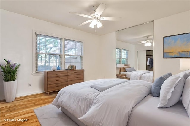 bedroom featuring light wood finished floors, a closet, baseboards, and a ceiling fan