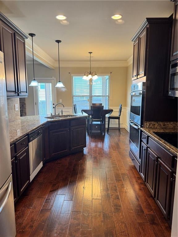 3897 Valley Bluff Ln, Snellville, GA 30039 - kitchen featuring stainless steel appliances, a sink, stone counters, dark wood-style floors, and crown molding