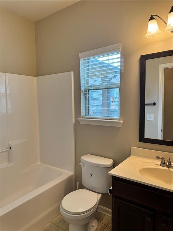 3897 Valley Bluff Ln, Snellville, GA 30039 - bathroom with tile patterned flooring, vanity, toilet, baseboards, and  shower combination