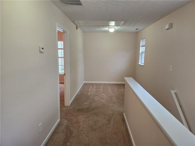 carpeted empty room with ceiling fan and a textured ceiling