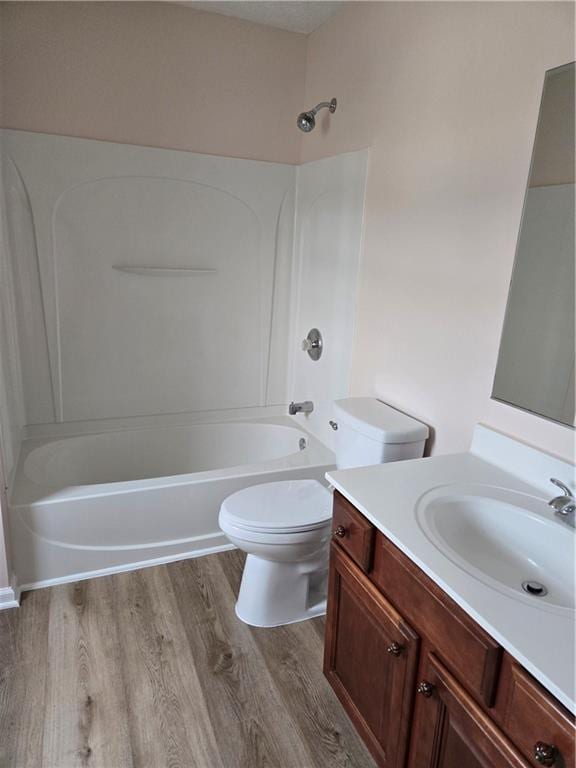 full bathroom with vanity, bathtub / shower combination, hardwood / wood-style floors, and toilet