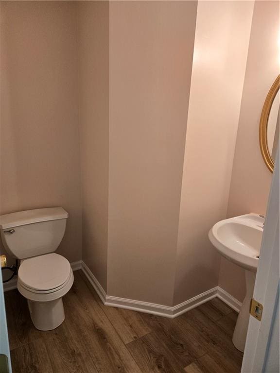 bathroom featuring wood-type flooring and toilet