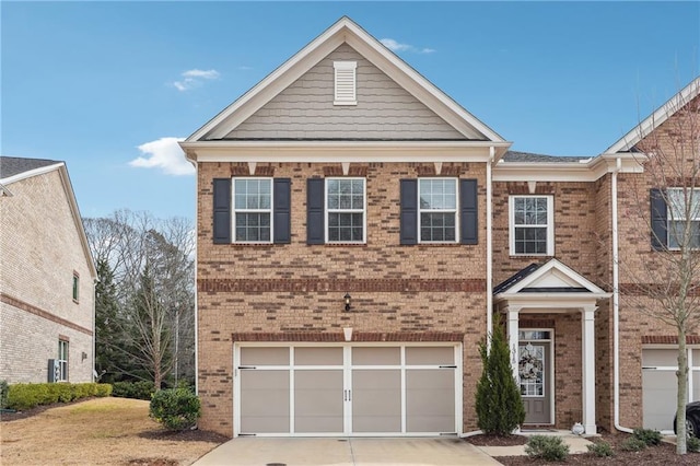 view of front of home featuring driveway, a garage, and brick siding