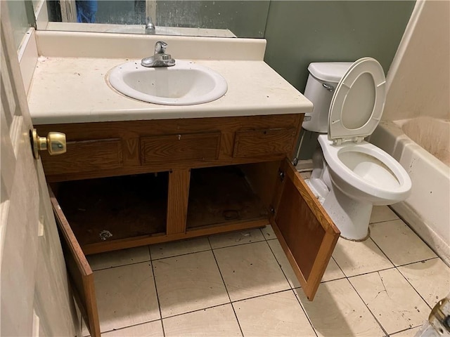 bathroom with tile patterned floors, a washtub, vanity, and toilet