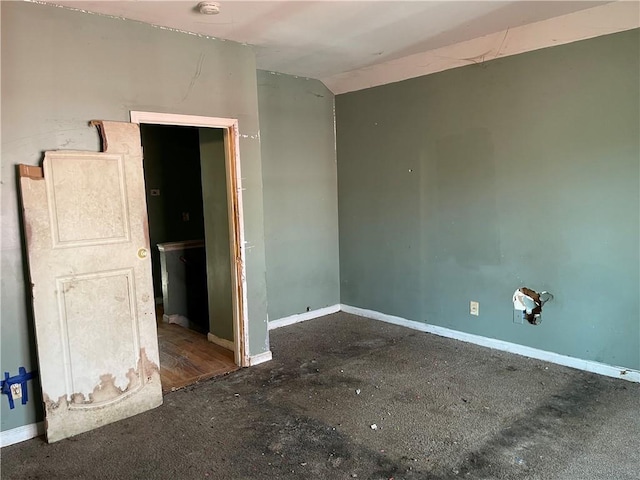 unfurnished room featuring lofted ceiling