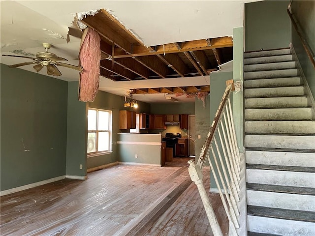 stairs featuring ceiling fan and wood-type flooring