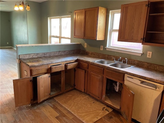 kitchen featuring dishwasher, light hardwood / wood-style flooring, a notable chandelier, and sink