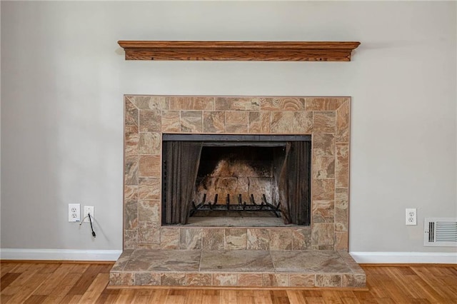 879 Rock Oak Ln, Lawrenceville, GA 30046 - detailed view of baseboards, wood finished floors, and a fireplace with raised hearth