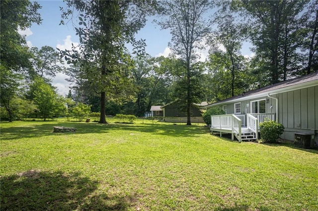 879 Rock Oak Ln, Lawrenceville, GA 30046 - view of grassy yard featuring a wooden deck, central air condition unit, and view of scattered trees