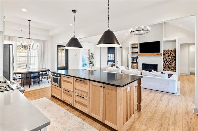 kitchen with light wood finished floors, a fireplace, freestanding refrigerator, light brown cabinetry, and dark countertops