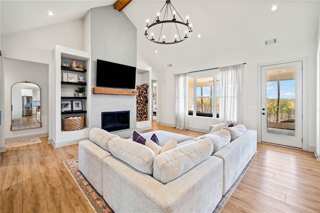 living room with light wood finished floors, visible vents, and a healthy amount of sunlight