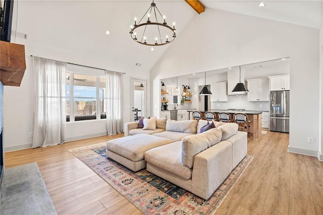 living room featuring light wood-type flooring, high vaulted ceiling, beamed ceiling, and a chandelier