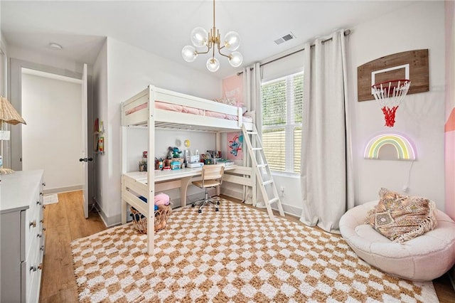 bedroom with a notable chandelier, light wood-style floors, visible vents, and baseboards