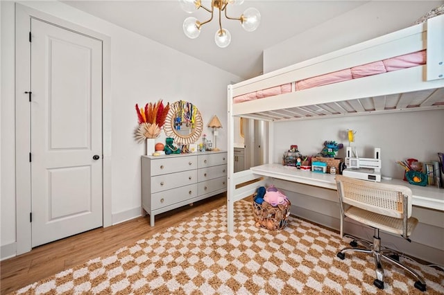 bedroom featuring a notable chandelier and wood finished floors