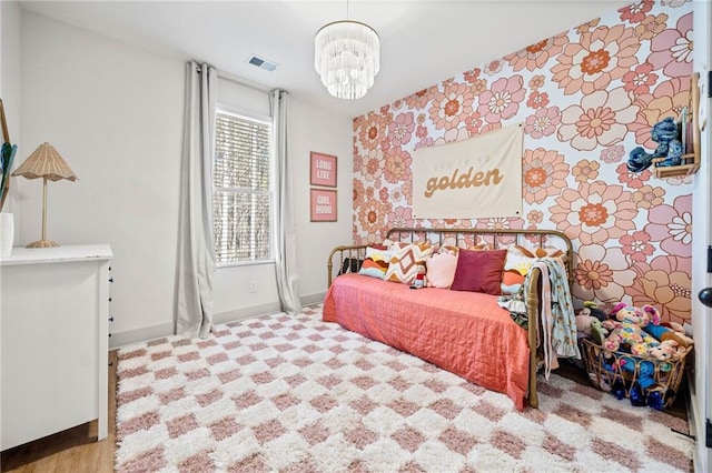 bedroom with a notable chandelier, visible vents, and baseboards