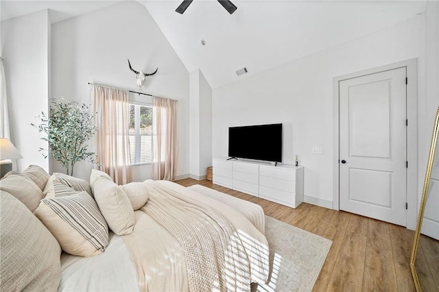 bedroom with visible vents, baseboards, high vaulted ceiling, and light wood finished floors