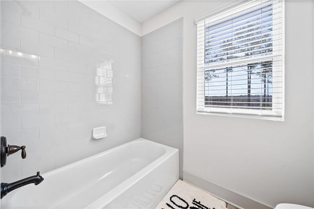 full bathroom featuring plenty of natural light and baseboards