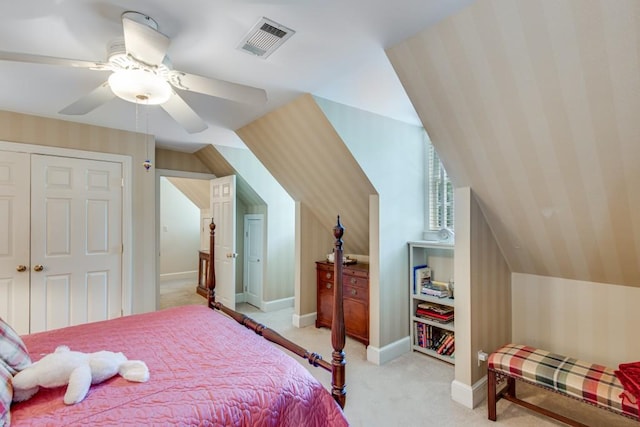 bedroom with lofted ceiling, light colored carpet, ceiling fan, and a closet