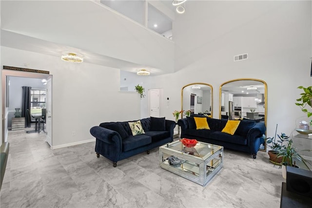 living room with visible vents, marble finish floor, baseboards, a high ceiling, and arched walkways