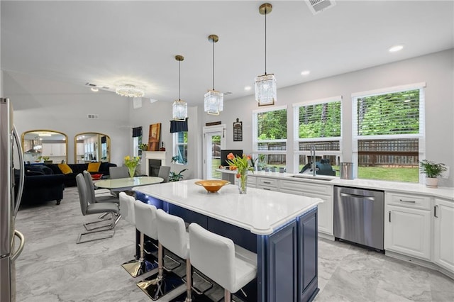 kitchen with visible vents, light countertops, white cabinets, a sink, and appliances with stainless steel finishes