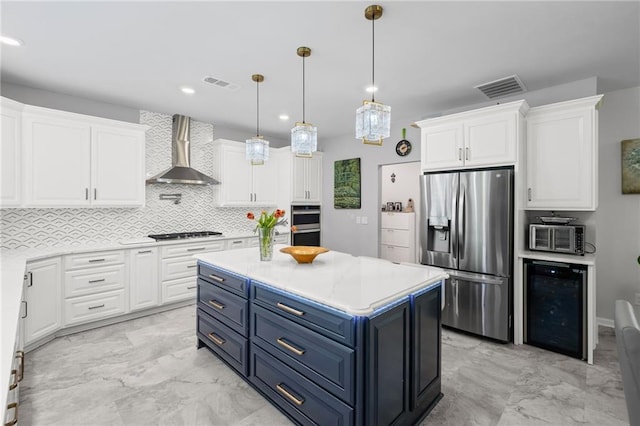 kitchen featuring wall chimney range hood, stainless steel fridge with ice dispenser, beverage cooler, blue cabinetry, and visible vents