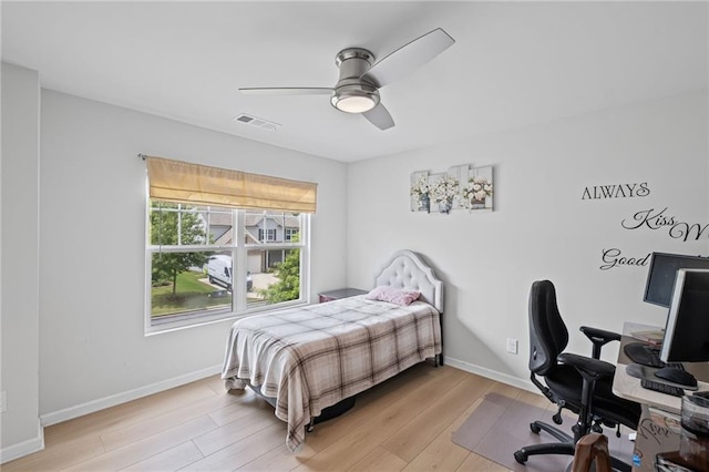bedroom with visible vents, light wood-style floors, ceiling fan, and baseboards