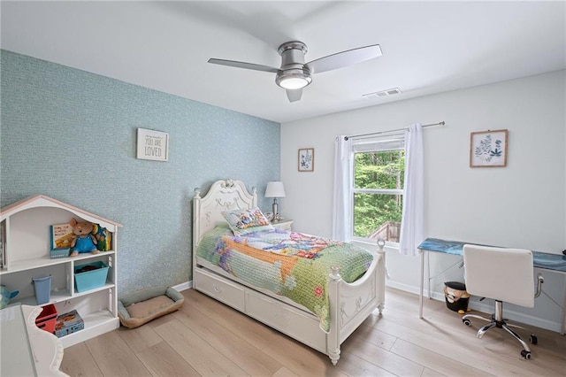 bedroom featuring ceiling fan, baseboards, visible vents, and wood finished floors