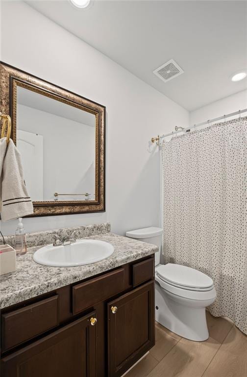 bathroom featuring toilet, visible vents, a shower with shower curtain, and vanity