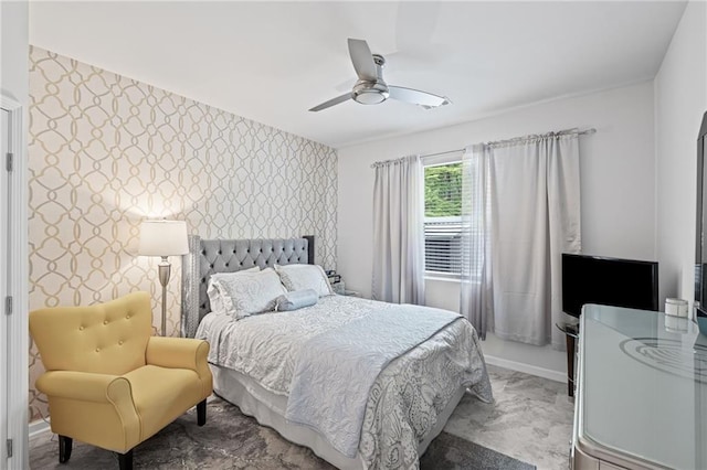 bedroom featuring a ceiling fan, an accent wall, and wallpapered walls