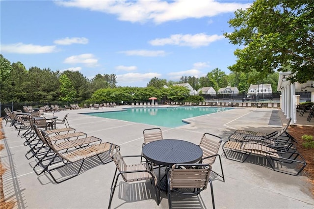 community pool with a patio and fence