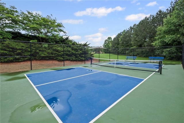 view of tennis court featuring fence