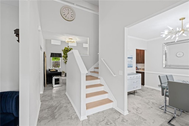 stairs with crown molding, baseboards, a chandelier, and marble finish floor