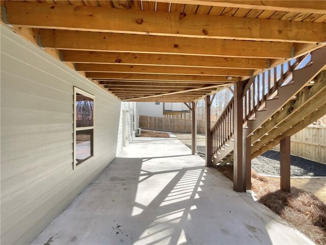 view of patio with fence and stairway