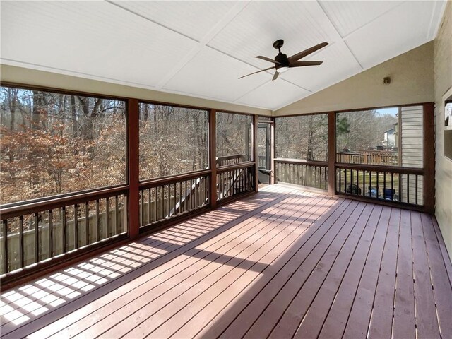 unfurnished sunroom with vaulted ceiling and a ceiling fan