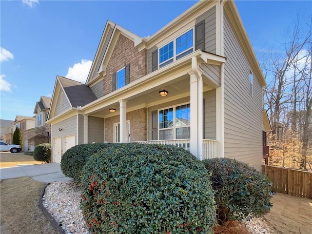 view of side of home featuring a porch and fence