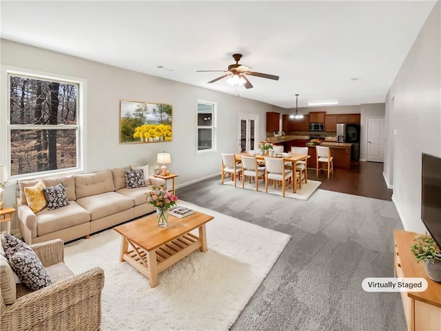 living room featuring a ceiling fan and baseboards