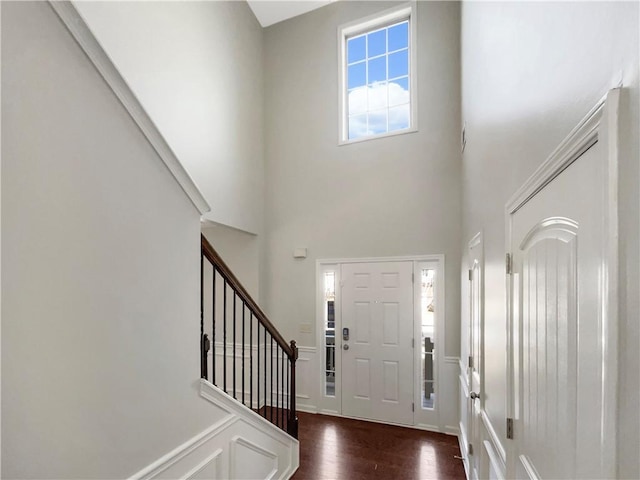 entrance foyer featuring stairs, a high ceiling, and dark wood finished floors